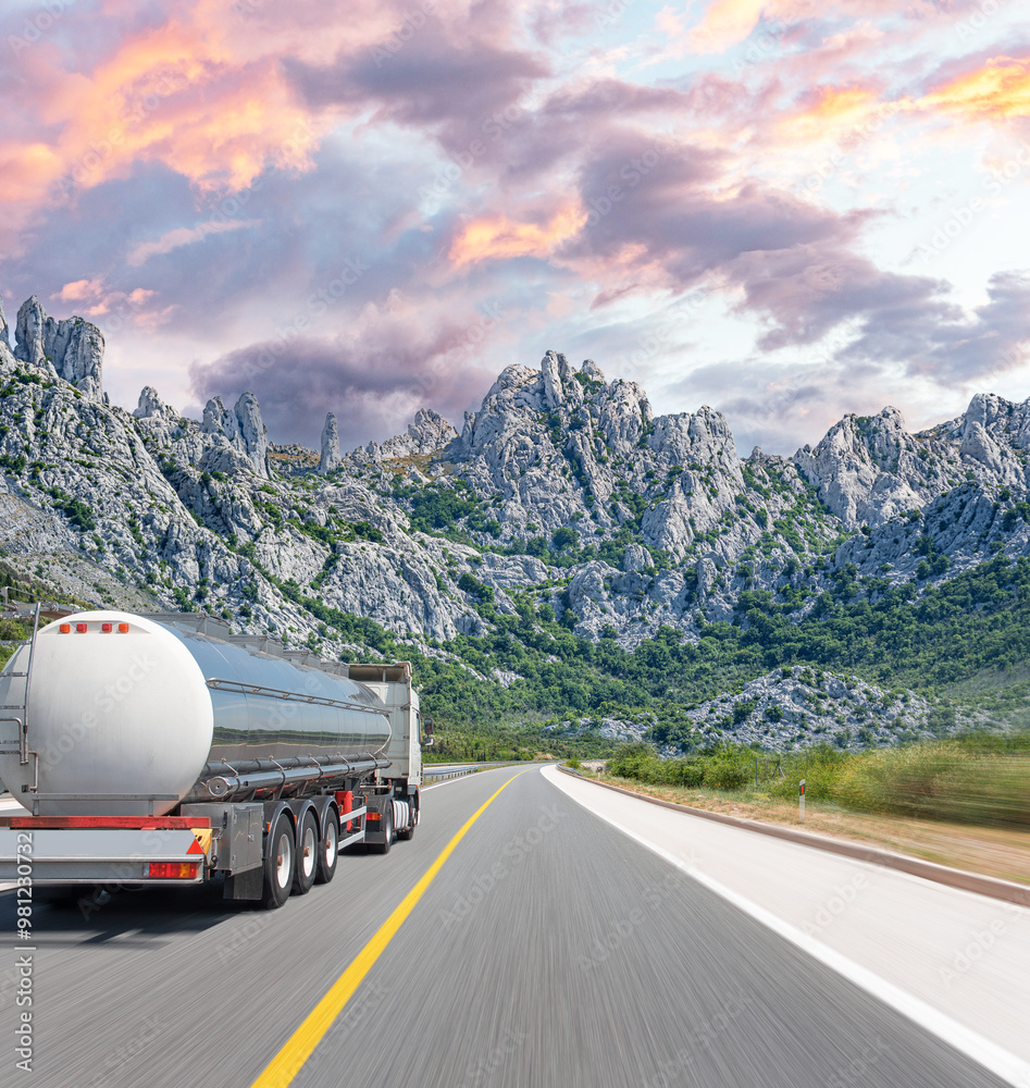 Fuel truck on a picturesque road. A silver tank truck transports fuel.