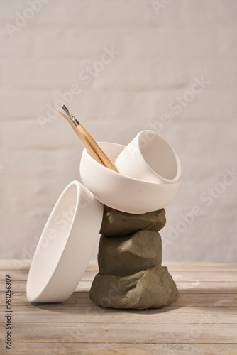 Ceramics workshop, contemporary photography with raw clay and white dishes.