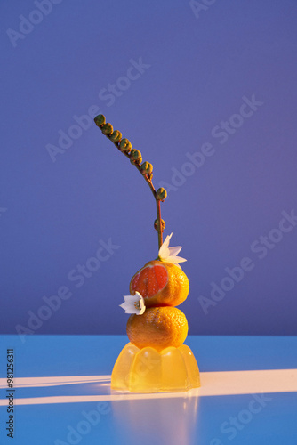 An abstract composition with citrus and flowers, contemporary photography