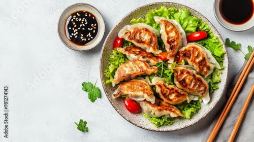 Grilled dumplings on lettuce with soy sauce and chopsticks