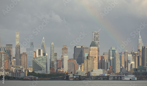 rainbow over the west side of manhattan new york city skyline (residential and commercial skyscraper buildings) view from nj nyc panorama rain bow colorful sky after rain apartment real estate photo