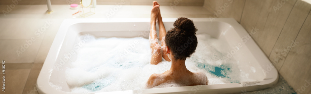 A woman enjoys a leisurely bath in a bathtub filled with bubbly water A woman enjoys a leisurely bath in a bathtub filled with bubbly water