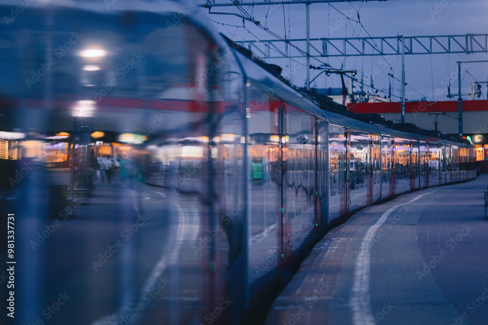 Fototapeta premium Electric train in the evening at the station. Railway platform.