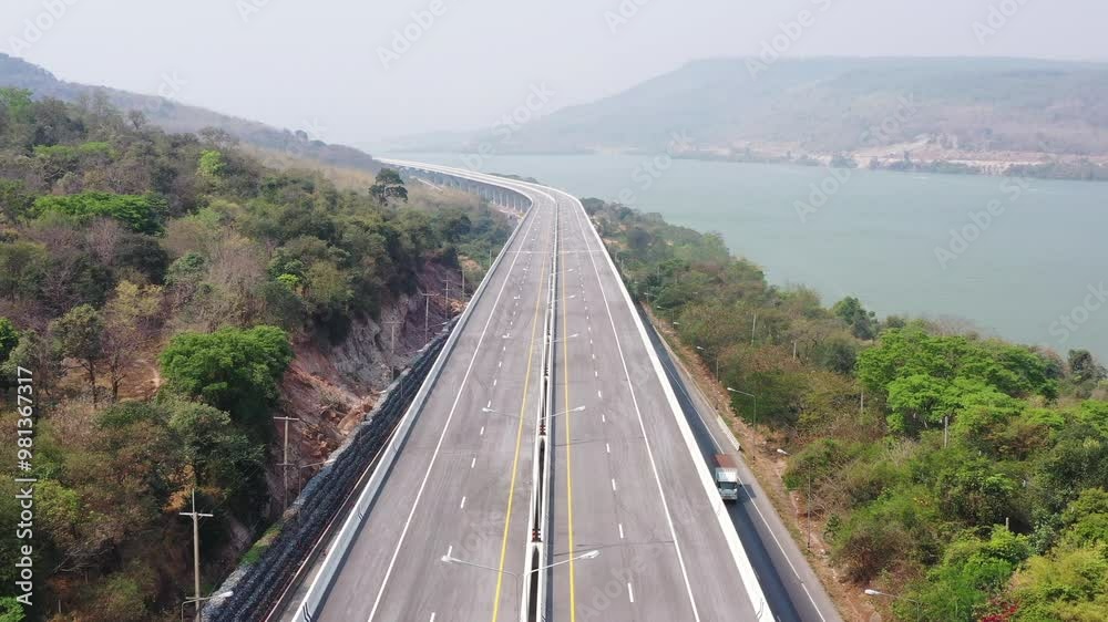 Motorway expressway parallel to the water in Lam Takhong Dam and the roadside mountains of Nakhon Ratchasima Province, Thailand, Asia Motorway expressway parallel to the water in Lam Takhong Dam and the roadside mountains of Nakhon Ratchasima Province, Thailand, Asia