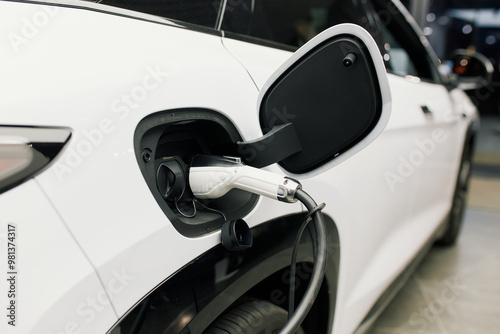 Close-up of a white electric car being refilled