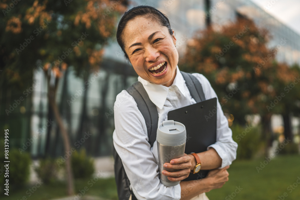 Mature japanese woman walk with backpack thermos and clipboard outdoor Mature japanese woman walk with backpack thermos and clipboard outdoor