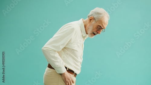 An elderly man holding his stomach in pain on a light background