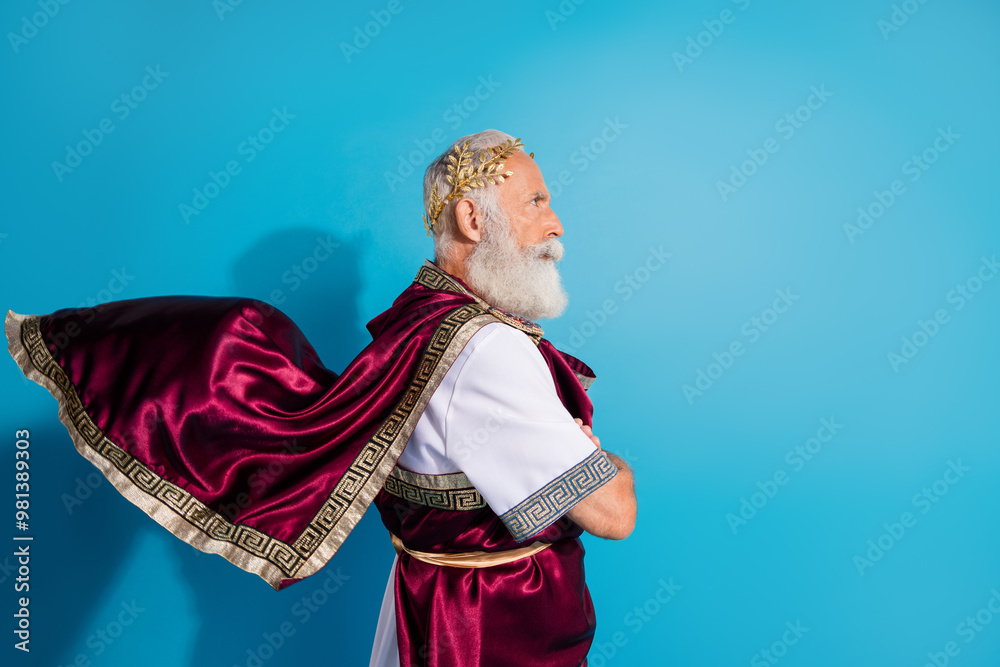 Fototapeta premium Photo of handsome senior male profile crossed hands confident wear ancient greek god king dress isolated on blue color background