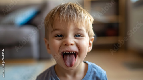 Little boy teasing someone, showing tongue and making a face
