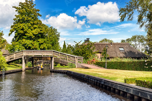 A tranquil riverside village with thatched-roof cottages and boats