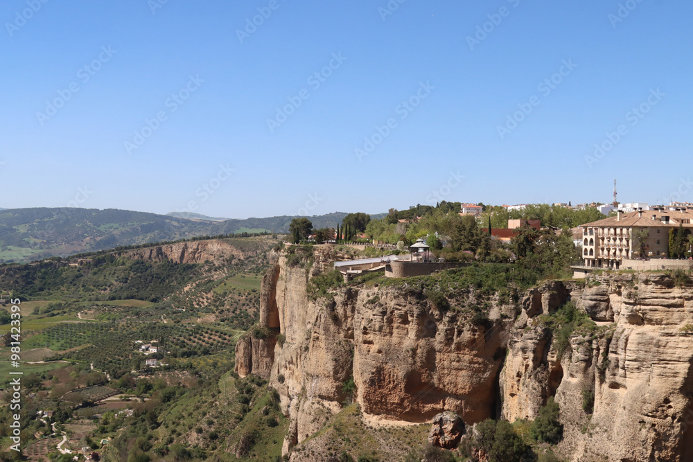 Ronda, spain, perched on cliff overlooking serene countryside with blue sky Ronda, spain, perched on cliff overlooking serene countryside with blue sky