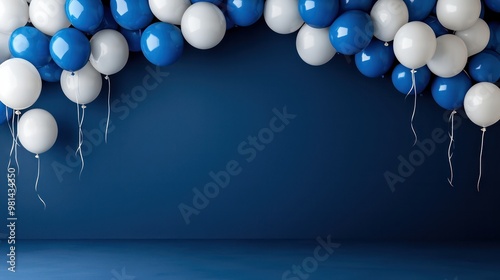 A blue and white balloon arch with white balloons hanging from the top. The balloons are tied to the ceiling with strings photo