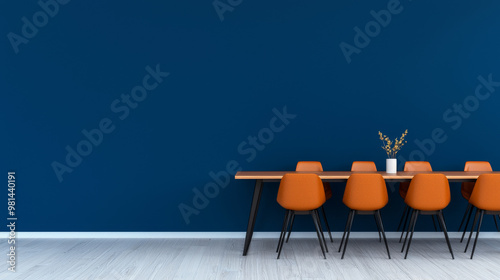 A minimalist dining room with a blue wall and orange chairs.