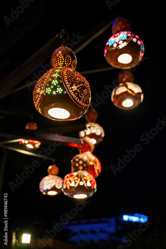 Obraz na płótnie A string of colorful, handcrafted gourd lanterns illuminated at night, creating a beautiful and festive atmosphere. w salonie