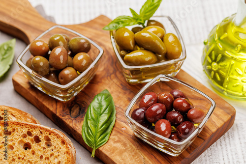 An assortment of various olives presented in a bowl, showcasing different colors, textures, and flavors