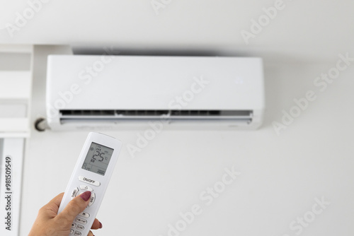 Fotografie Adjusting air conditioner temperature with remote control