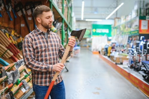 happy customer in a hardware store buying a new ax photo