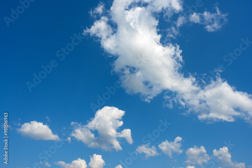 white cumulus clouds ruffled by the strong wind in the blue sky