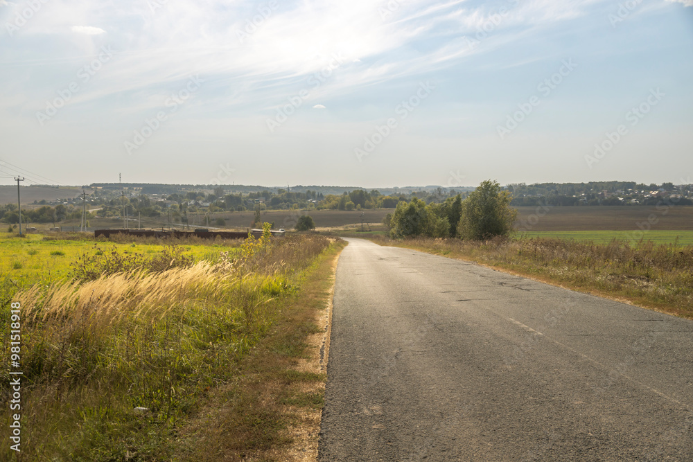 A road with a grassy field on either side A road with a grassy field on either side