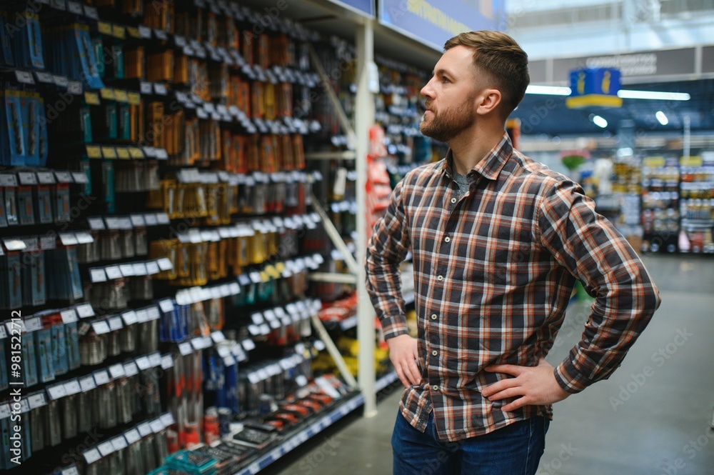 handsome young man shopping for tools at hardware store handsome young man shopping for tools at hardware store