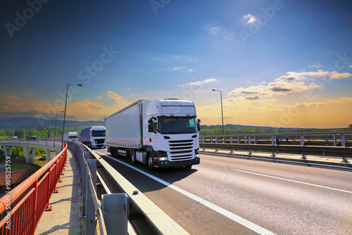 Large Transportation Truck on a highway road through the countryside at sunset