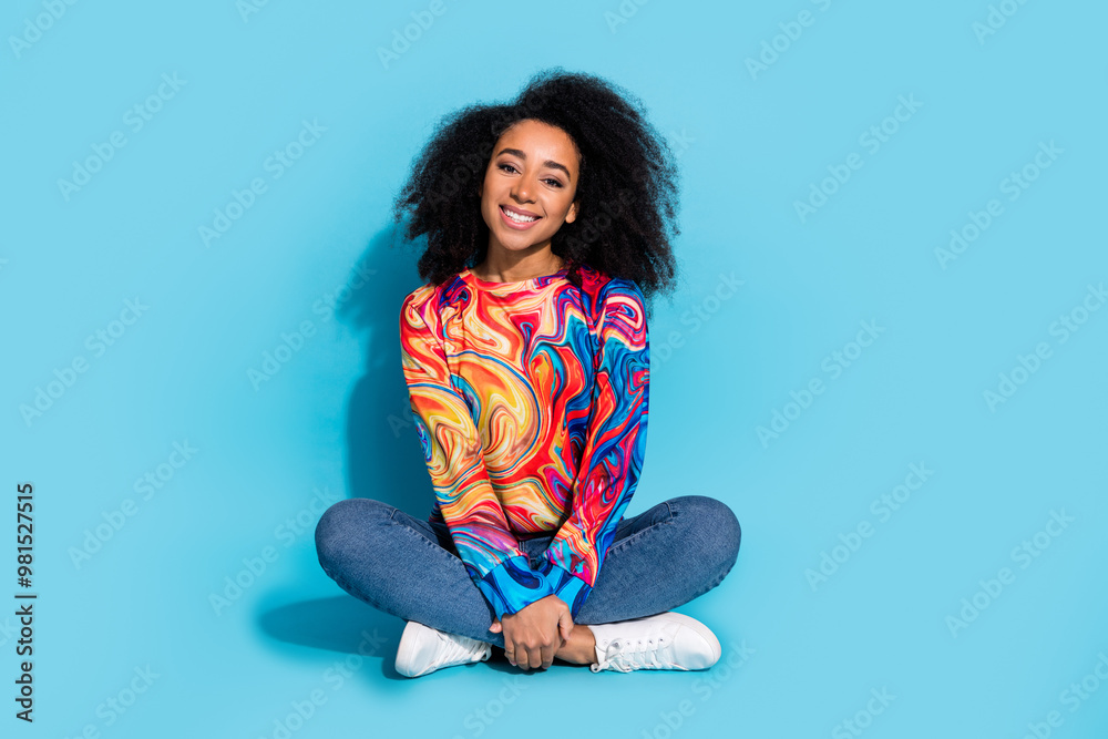 Full body photo of attractive young woman sit floor crossed legs dressed stylish colorful clothes isolated on blue color background Full body photo of attractive young woman sit floor crossed legs dressed stylish colorful clothes isolated on blue color background