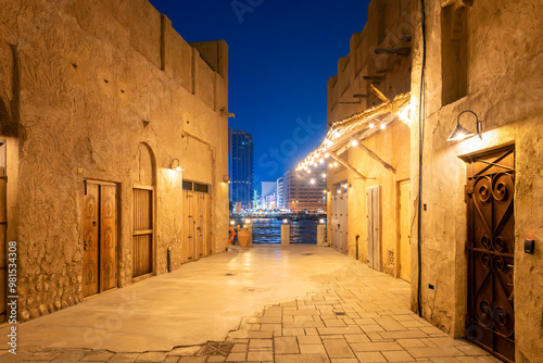Photography Night view from Al Seef historical waterfront shopping district, looking across Dubai Creek at the illuminated downtown and souk district in Dubai, United Arab Emirates