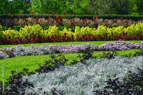 A nicely landscaped area of the Washington Park Gardens in Denver, Colorado with Calla Lilies, Fountain Grass, Coleus, Petunias, Capsicum and Dusty Miller plants.