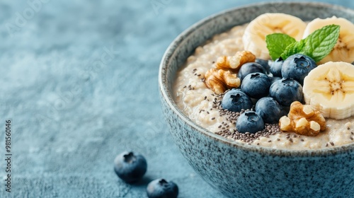 This image displays a nutrient-rich oatmeal bowl adorned with fresh blueberries, banana slices, walnuts, and chia seeds, providing a balanced and appetizing breakfast option. photo