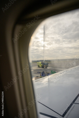 view from airplane window of firetruck water cannon salute photo