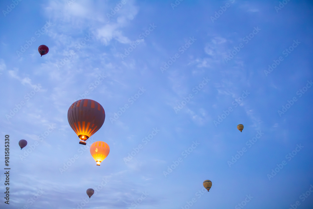 Hot air balloons glowing at dawn over Cappadocia's serene sky, creating a magical contrast with the soft morning clouds. Hot air balloons glowing at dawn over Cappadocia's serene sky, creating a magical contrast with the soft morning clouds.