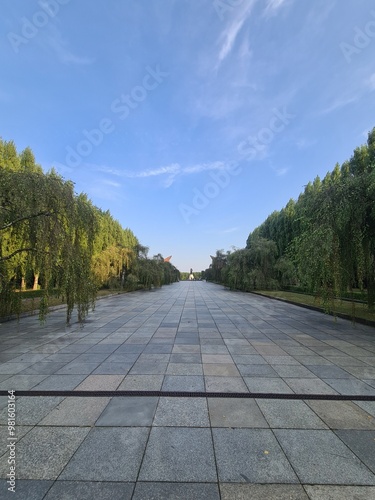 Pfad mit Bäumen an den Seiten und atmosphärischem Himmel zum sowjetischen Ehrenmal im Treptower Park, Berlin photo