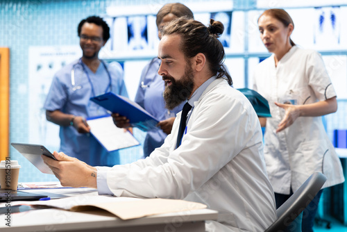 Professional medics examine healthcare records and treatment plans in a private clinic to ensure medical insurance services. Doctor and his staff analyzing test results for healing solutions. photo