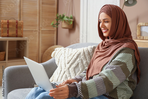 Canvas Print Young Muslim woman using laptop at home