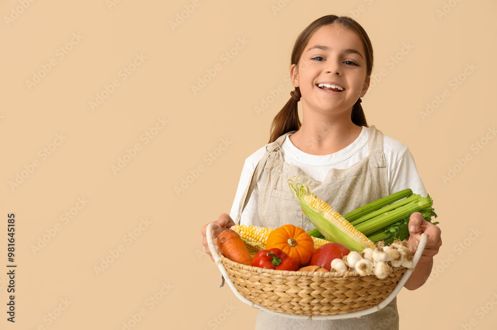 Little farmer with fresh food on beige background Little farmer with fresh food on beige background