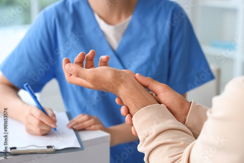 Φωτογραφία Young man with pain in his wrist visiting doctor at hospital, closeup