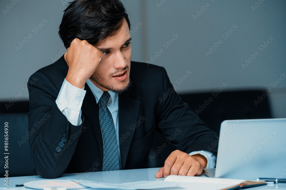 Unhappy young man, businessman feels stress at the office because of economic crisis and awful company loss. Business failure concept. uds