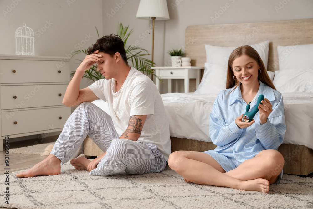 Young woman with vibrator and her upset husband in bedroom. Sexual problems concept Young woman with vibrator and her upset husband in bedroom. Sexual problems concept