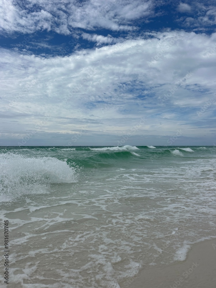 Obraz premium Large waves and fluffy white clouds over Gulf of Mexico Florida Emerald Coast 