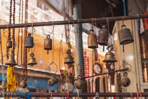 Old brass bells for sale at an outdoor market.