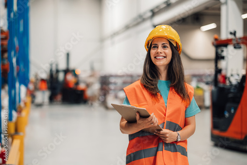 Female content warehouse assessor evaluates inventory amidst stacks