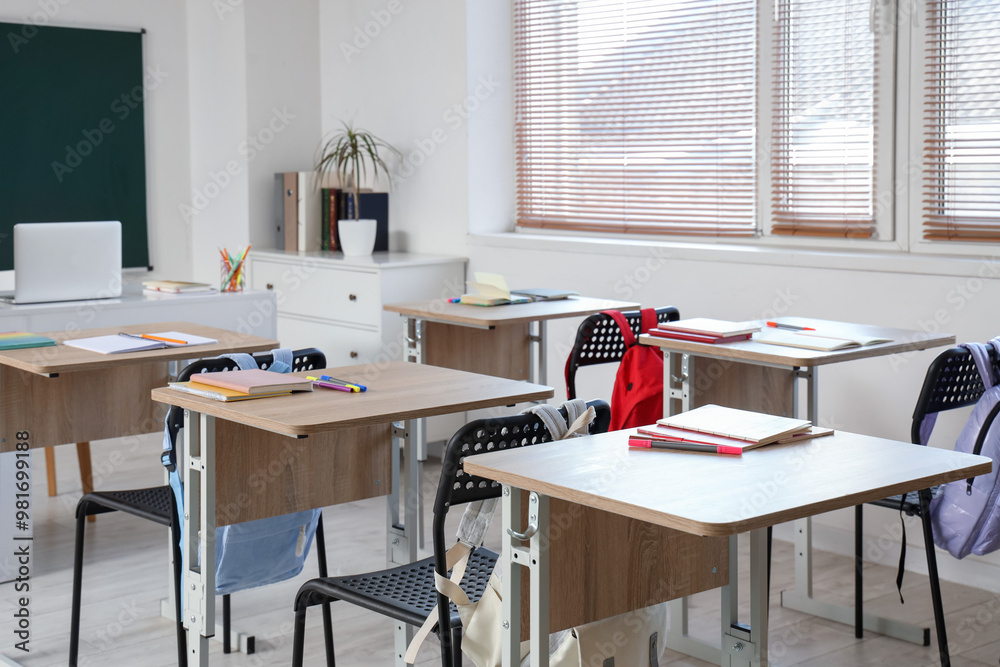 Interior of empty classroom with school desks and greenboard Interior of empty classroom with school desks and greenboard