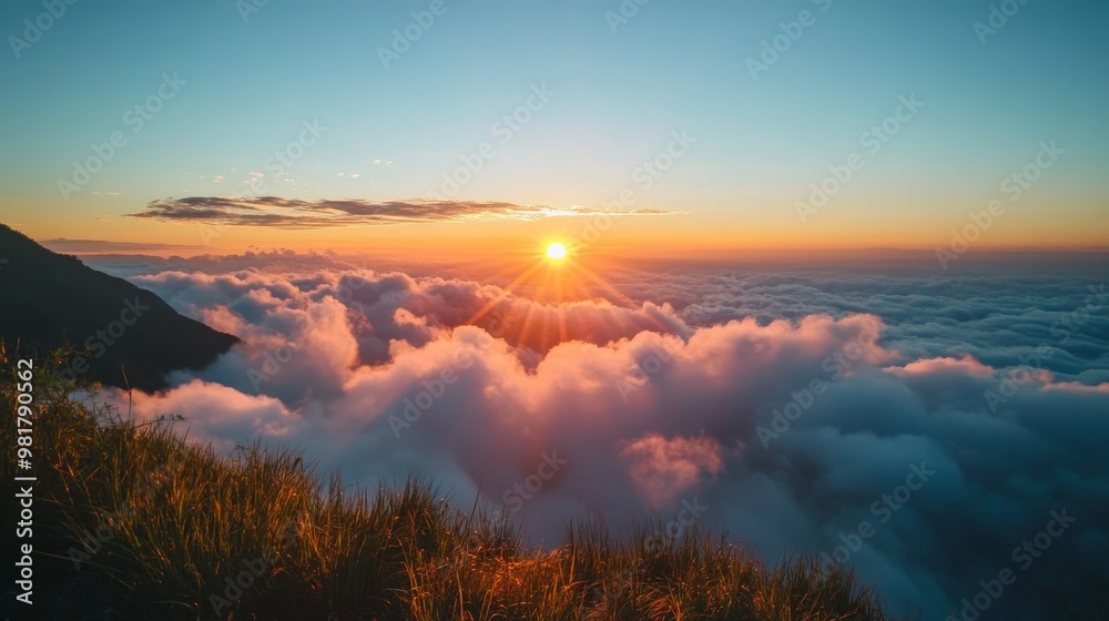 Fototapeta premium 60. 4K timelapse footage of a majestic sunrise viewed from a high mountain, showing the sun rising from the horizon, creating a stunning display of golden light on the clouds against a blue sky