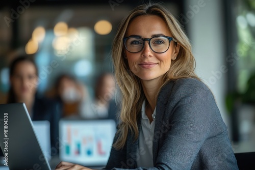 Portrait of woman leader presenting business strategy on laptop in modern office