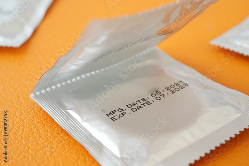 A closeup view of an condom package with expire date 