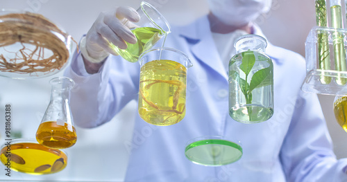 A lab technician pours a vibrant green liquid into a beaker, surrounded by various glass containers, template illustrating the process of experimentation with botanical extracts in laboratory setting photo