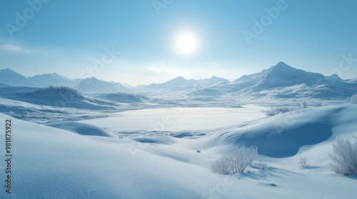 Snow-Covered Mountain Range with Frozen Lake and Bright Sun