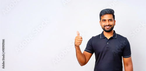 A portrait of a South Asian man in a black polo shirt giving a thumbs up.
