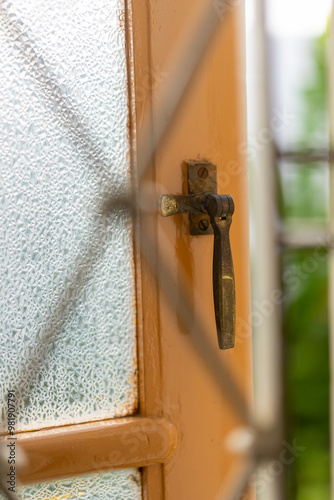 Close up of Old vintage window hardware. Old vintage iron handle on brown wooden window.