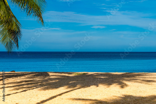 Fototapeta Naklejka Na Ścianę i Meble -  Beach sand background for summer vacation concept. Nature of the beach and sea, summer with sunlight, sandy beach The sparkling sea water contrasts with the blue sky and coconut trees.	